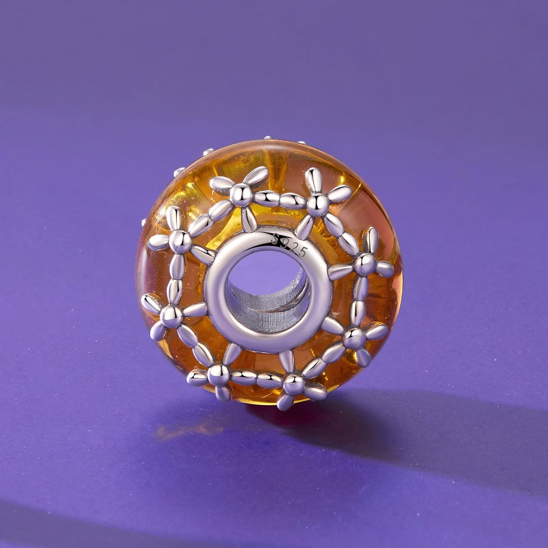 Home 24 Orange Floral Glass Charm featuring glowing marigold-inspired glass bead with sterling silver floral detailing around the edges.