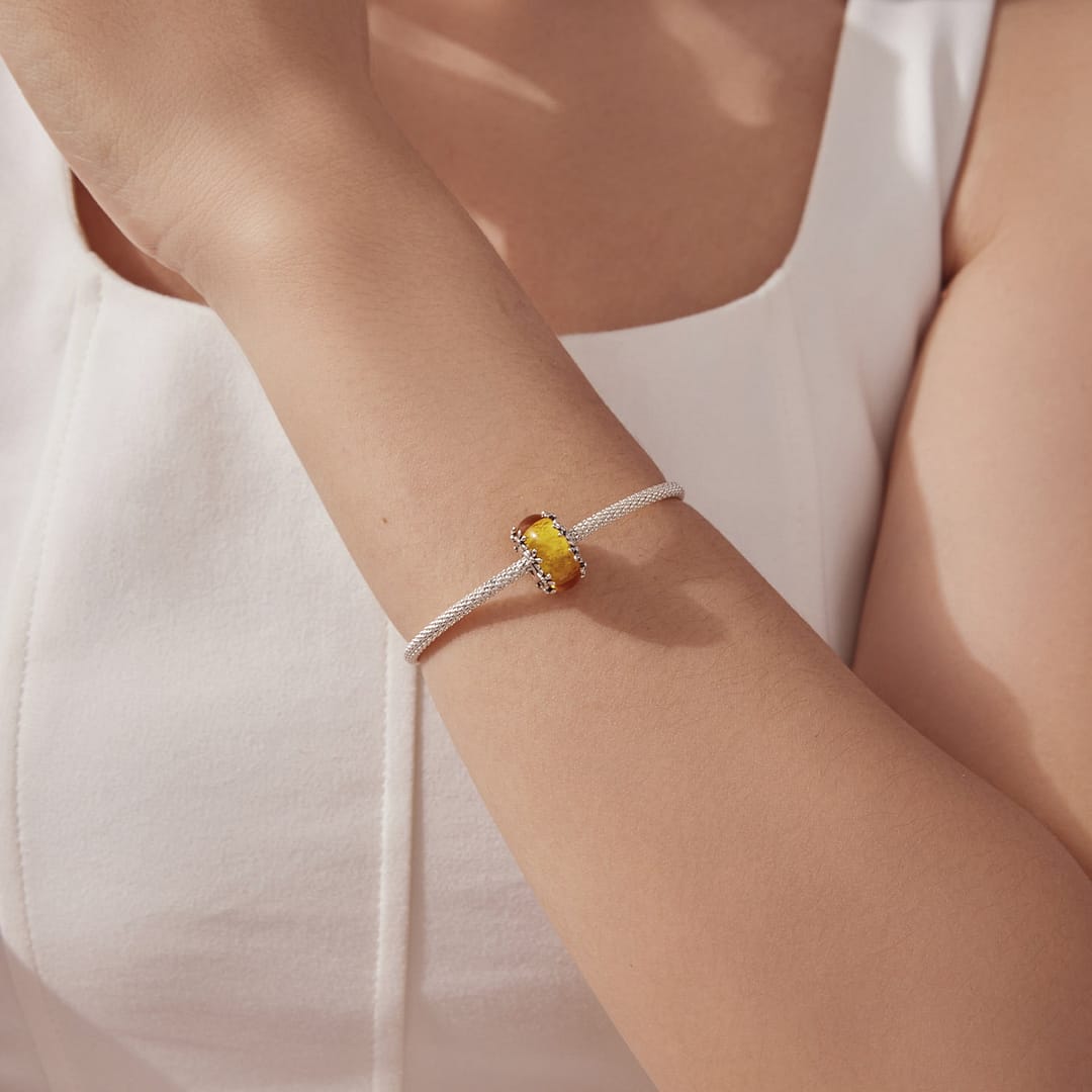 Home 25 Orange Floral Glass Charm featuring glowing marigold-inspired glass bead with sterling silver floral detailing around the edges.