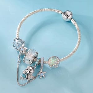 Discover Magic in Every Detail with the Fairy Charms Collection 6 S925 sterling silver Sea Whisper Fairy charm with shimmering aqua enamel and seashell detail