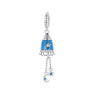 Photo of Moon Star Rocket Dangle Charm from the Parallel Universe Charms Collection. The charm is crafted from s925 sterling silver, featuring a silver rocket with a blue core, adorned with cubic zirconia stones, and two chains with a small moon and star.
