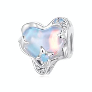 Sterling silver heart charm filled with light blue glass resembling the milky way, encrusted with opal and cubic zirconia stars.