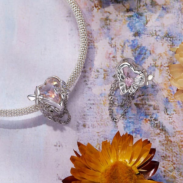 Buzzworthy Beauties: 10 Must-Have Bug-Inspired Jewelry Pieces of 2023 28 Sterling silver charm featuring opal-studded butterflies on heart-shaped pink glass, part of Monet's Garden Charms Collection