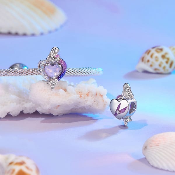 Dive into Style: 10 Must-Have Ocean-Inspired Jewelry Pieces of 2023 40 Sterling silver heart charm with pink glass center, opal, and cubic zirconia stones. Features a mermaid with pink and purple tail on one side. Back engraved with mermaid tail.