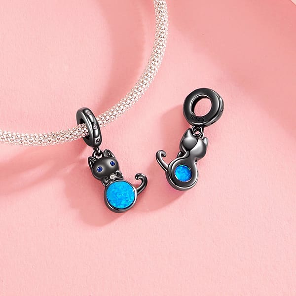 Celebrate Your Love for Pets on National Love Your Pet Day 10 Elegant Black Cat Dangle Charm in s925 sterling silver, plated in black gold, featuring blue opal, cubic zirconia eyes, and a bow accent. Hypoallergenic and perfect for charm bracelets & necklaces. A must-have for cat lovers!