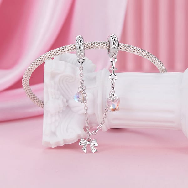 Buzzworthy Beauties: 10 Must-Have Bug-Inspired Jewelry Pieces of 2023 35 Sterling silver Ballet Safety Chain featuring pink butterfly, silver ribbon bow, and blue moonstone heart charms.