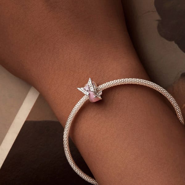 Buzzworthy Beauties: 10 Must-Have Bug-Inspired Jewelry Pieces of 2023 16 Monet's Garden Butterflies Dream Spacer Charm: Sterling silver spacer charm with pink enamel, featuring two silver butterflies and pink glass crystal.