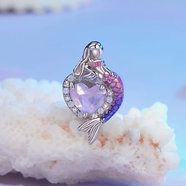 Dive into Style: 10 Must-Have Ocean-Inspired Jewelry Pieces of 2023 38 Sterling silver heart charm with pink glass center, opal, and cubic zirconia stones. Features a mermaid with pink and purple tail on one side. Back engraved with mermaid tail.