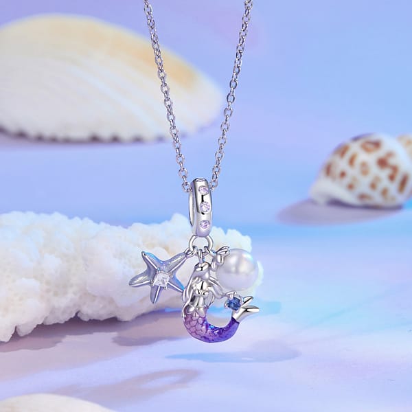Dive into Style: 10 Must-Have Ocean-Inspired Jewelry Pieces of 2023 35 Mermaid Dangle Charm featuring a pink and purple mermaid, green enamel starfish with cubic zirconia, and shell pearl.