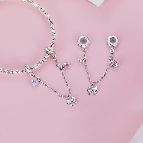 Buzzworthy Beauties: 10 Must-Have Bug-Inspired Jewelry Pieces of 2023 33 Sterling silver Ballet Safety Chain featuring pink butterfly, silver ribbon bow, and blue moonstone heart charms.
