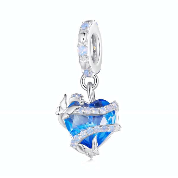 Buzzworthy Beauties: 10 Must-Have Bug-Inspired Jewelry Pieces of 2023 17 Cinderella Magic Glass Heart Dangle Charm crafted from s925 sterling silver, featuring a blue glass heart wrapped in opal-adorned silver swirls with butterfly accents.