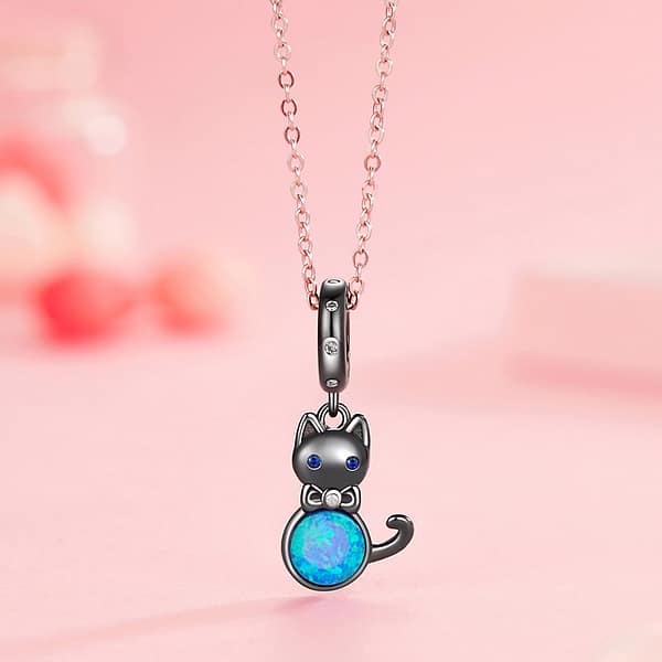 Celebrate Your Love for Pets on National Love Your Pet Day 12 Elegant Black Cat Dangle Charm in s925 sterling silver, plated in black gold, featuring blue opal, cubic zirconia eyes, and a bow accent. Hypoallergenic and perfect for charm bracelets & necklaces. A must-have for cat lovers!