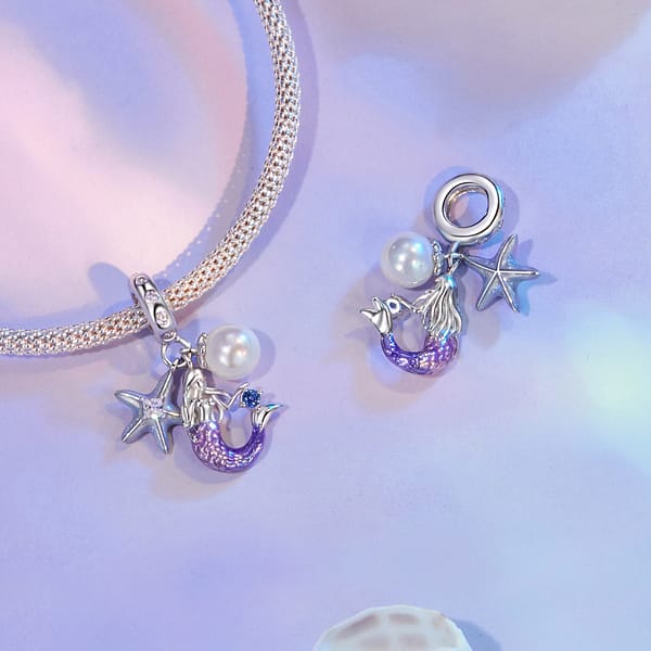 Dive into Style: 10 Must-Have Ocean-Inspired Jewelry Pieces of 2023 33 Mermaid Dangle Charm featuring a pink and purple mermaid, green enamel starfish with cubic zirconia, and shell pearl.